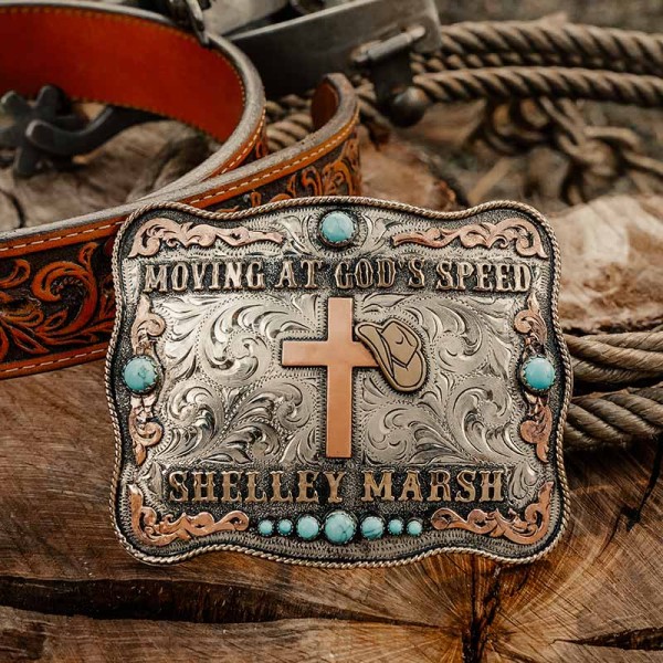 A custom women's cross belt buckle featuring a personalized quote and and name, and turquoise stones